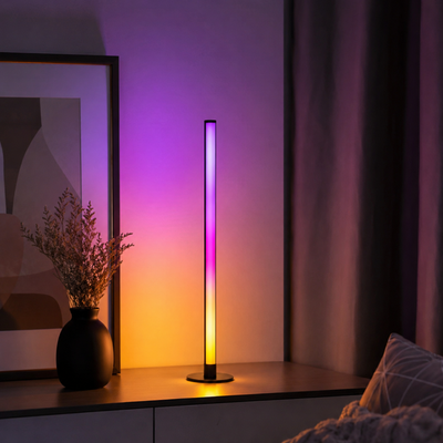 Lámpara LED RGB encendida con degradado de colores en un rincón moderno
